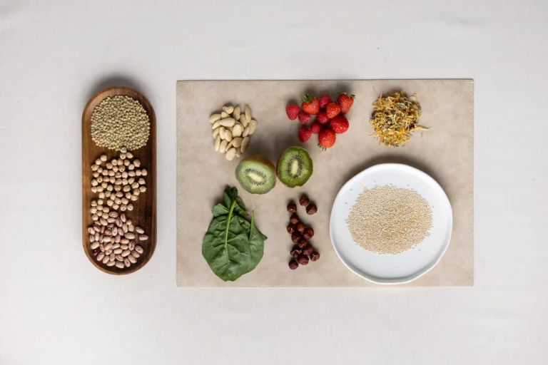 Legumi su un vassoio di legno con fragole, kiwi, spinaci, mandorle, nocciole e riso
